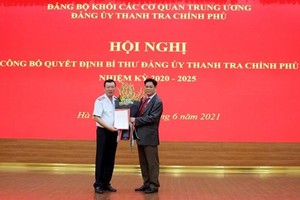 Bí thư Đảng ủy Khối các cơ quan Trung ương Huỳnh Tấn Việt trao quyết định và tặng hoa tân Bí thư Đảng ủy Thanh tra Kl993 ưu đãi thưởng hấp dẫn Đoàn Hồng Phong (trái). (Nguồn: thanhtra.com.vn).
