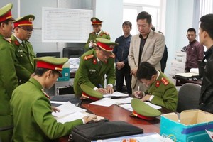 Lực lượng chức năng khám xét, thu giữ nhiều tài liệu liên quan đến sai phạm tại Ban Quản lý dự án Môi trường và Biến đổi khí hậu thành phố Đồng Hới.
