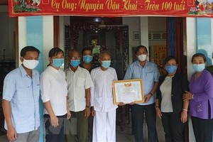 Cụ ông Nguyễn Văn Khai (thứ 5 từ trái sang), 100 tuổi, ngụ tại khóm Mỹ Thới, thị trấn Mỹ Thọ, huyện Cao Lãnh, Đồng Tháp, đã đóng góp tiền tiết kiệm cho Quỹ phòng, chống dịch bệnh COVID-19 và được Lãnh đạo Ủy ban MTTQ Việt Nam tỉnh Đồng Tháp đến trao Bằng khen Về hành động nhân ái ủng hộ phòng, chống dịch bệnh COVID-19. (Ảnh: TTXVN phát)