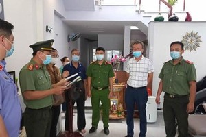 Thi hành quyết định khởi tố bị can, bắt tạm giam đối với Lee Kwan Young (áo trắng). (Ảnh: Công an cung cấp).