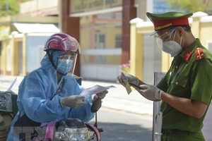 Lực lượng chức năng tại các chốt kiểm tra các loại giấy tờ của shipper. (Ảnh: Văn Dũng/TTXVN).