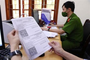 Giấy đi đường có mã nhận diện được lực lượng công an phường Văn Quán, quận Hà Đông đối chiếu và xét duyệt để cấp cho các cá nhân và Kl991.com World Cup 2026 Chính Thức thực hiện dịch vụ công ích thiết yếu trên địa bàn. (Ảnh: Phạm Kiên/TTXVN).