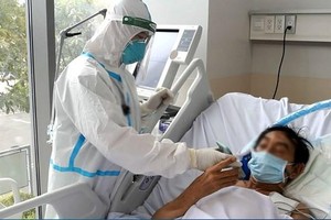 Nhân viên y tế chăm sóc cho bệnh nhân mắc COVID-19. (Ảnh: PV/Vietnam+).