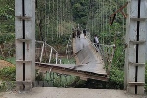 Cầu treo Nam Quang bị đứt gãy khiến xe tải chở hàng rơi xuống sông. (Ảnh: TTXVN phát).