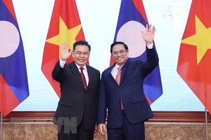 Thủ tướng Phạm Minh Chính và Chủ tịch Quốc hội Lào Saysomphone Phomvihane chụp ảnh chung. (Ảnh: Dương Giang/TTXVN).