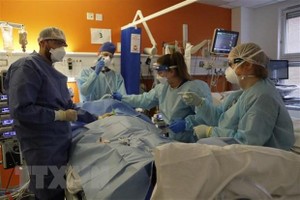 Nhân viên y tế điều trị cho bệnh nhân COVID-19 tại bệnh viện ở London, Anh. (Ảnh: AFP/TTXVN).