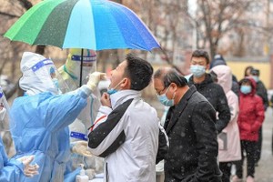Nhân viên y tế lấy mẫu xét nghiệm COVID-19 cho người dân tại tỉnh Cát Lâm, Trung Quốc ngày 12/3/2022. (Ảnh: THX/TTXVN).