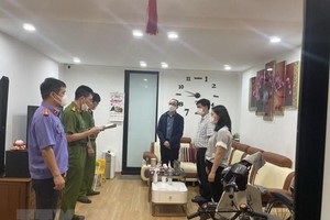 Cơ quan Công an thi hành quyết định khởi tố bị can và lệnh bắt bị can để tạm giam đối với Nguyễn Tấn Hoàng. (Ảnh: Thái Hùng/TTXVN).