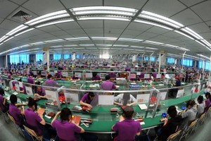 Công nhân làm việc trong một nhà máy Kl994 nhà cái bóng đá world cup điện tử ở tỉnh An Huy, miền Đông Trung Quốc. Ảnh: AFP/TTXVN