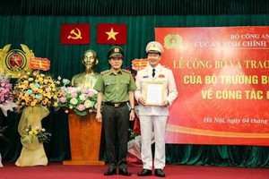 Thứ trưởng Lương Tam Quang trao quyết định, tặng hoa chúc mừng Thiếu tướng Vũ Hồng Văn, tân Cục trưởng Cục An ninh Kl991.com tải ứng dụng nội bộ. (Nguồn: Tiền Phong).
