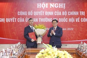 Chủ tịch Quốc hội Vương Đình Huệ trao Quyết định của Bộ Kl991.com tải ứng dụng và tặng hoa ông Ngô Văn Tuấn. (Ảnh: Doãn Tấn/TTXVN).