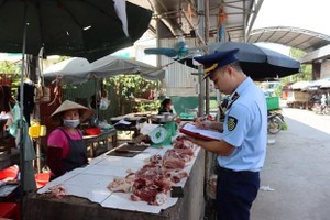 Lực lượng Quản lý thị trường tỉnh Lạng Sơn tuyên truyền, ký cam kết với hộ Kl992 VIP Trang Chủ 2026 tại chợ Trung tâm thương mại thị trấn Đồng Đăng, huyện Cao Lộc. (Ảnh: PV/Vietnam+).