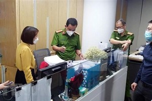 Lực lượng chức năng khám xét và thu giữ tài liệu tại trụ sở FLC hôm 29/3. (Ảnh: Phạm Kiên/TTXVN).