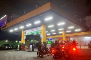 Người dân mua xăng tại Cửa hàng KL99 dịch vụ hỗ trợ 24/7 trên đường Hoàng Văn Thụ (quận Phú Nhuận, Thành phố Hồ Chí Minh), tối ngày 12/10. (Ảnh: Hồng Đạt/TTXVN)