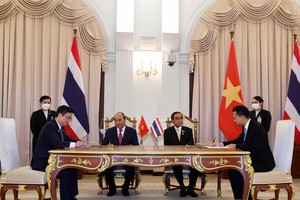 Đại diện Vietcombank, ông Nguyễn Thanh Tùng, Phó Tổng Giám đốc phụ trách Ban Điều hành (bên trái) và đại diện Eximbank Thái Lan, Ts. Rak Vorrakitpokatorn, Tổng Giám đốc (bên phải) ký kết thỏa thuận hợp tác trước sự chứng kiến của Chủ tịch nước Cộng hòa XHCN Việt Nam Nguyễn Xuân Phúc và Thủ tướng Thái Lan Prayuth Chan-ocha. Ảnh: TTXVN
