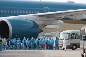 Các công dân xuống máy bay vào xe để về khu cách ly y tế. (Ảnh: Thành Đạt/TTXVN)