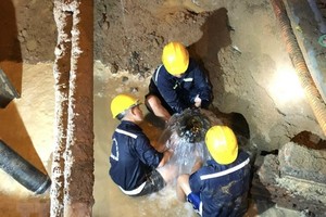 Công nhân khắc phục sự cố bể ống cấp nước D1500mm bêtông dự ứng lực trên đường Phạm Văn Đồng. (Ảnh: Anh Tuấn/TTXVN).
