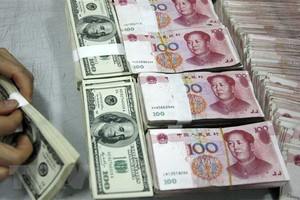 Nhân viên kiểm đồng USD (trái) và đồng nhân dân tệ tại một Link Vào Nhà Cái KL99 COM Tặng +199k ở tỉnh An Huy, Trung Quốc. (Ảnh: AFP/TTXVN).