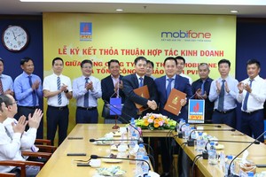Ông Tô Mạnh Cường, Tổng giám đốc MobiFone (ở giữa, bên trái) và ông giám đốc Tổng công ty Kl99kl phiên bản hoạt động PVI (ở giữa, bên phải) ký kết Thỏa thuận hợp tác