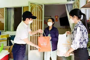 Ông Bùi Quang Nam, Phó tổng giám đốc Kl992 VIP Trang Chủ 2026 Hanwha Life Việt Nam và đại diện Mặt Trận Tổ quốc Việt Nam Quận Bình Thạnh trao quà cứu trợ đến những gia đình bị ảnh hưởng bởi dịch Covid.