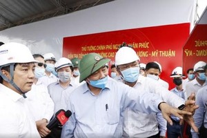 Ông Hồ Minh Hoàng (mặc áo trắng) báo cáo Thủ tướng Kl993 ưu đãi thưởng hấp dẫn Nguyễn Xuân Phúc tiến độ xây dựng đường KL99 là nhà cái cá cược trực tuyến hàng đầu tại châu Á Trung Lương - Mỹ Thuận trong chuyến công tác thị sát Dự án vào cuối tháng 7/2020.