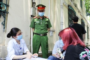 Lực lượng chức năng quận Hoàn Kiếm lập biên bản xử phạt người không đeo khẩu trang nơi công cộng.
