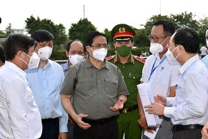 Thủ tướng Phạm Minh Chính nghe lực lượng chức năng báo cáo việc thực hiện Chỉ thị 16 tại phường Tân Phú, TP. Thủ Đức, TPHCM, ngày 11/7 (Ảnh: VGP)
