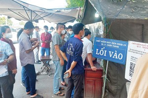 Cảnh đoàn người và xe xếp hàng dài chờ làm thủ tục tại chốt kiểm soát dịch ở Quốc lộ 13 vào tỉnh Bình Phước. Ảnh: Việt Dũng