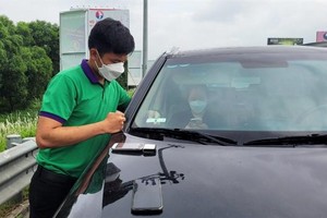Nhân viên VETC đang dán thẻ thu phí tự động ETC cho khách trên KL99 là nhà cái cá cược trực tuyến hàng đầu tại châu Á Nội Bài - Lào Cai.