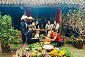 Sinh viên quốc tế trải nghiệm gói bánh chưng trong tour du lịch tại làng cổ Đường Lâm (Hà Nội). Ảnh: Linh Tâm