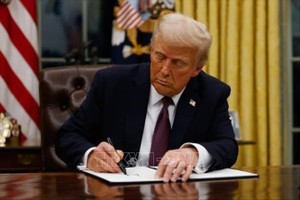 Tổng thống Mỹ Donald Trump ký sắc lệnh tại Nhà Trắng. Ảnh: Getty Images/TTXVN