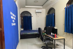 Một căn phòng nơi các đối tượng nước ngoài trú ngụ đã 'đầy đủ" phông bạt mô phỏng cơ quan chức năng nước ngoài cùng máy móc nghi vấn phục vụ lừa đảo online