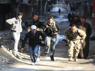 Các nhà báo mạo hiểm băng qua một con đường trong thành phố đang có chiến sự Aleppo ở Syria năm 2012 - Ảnh: Reuters