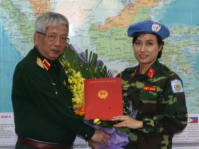 Thượng Tướng Nguyễn Chí Vịnh, Thứ trưởng Bộ quốc phòng, trao quyết định của Chủ tịch nước cho thiếu tá Đỗ Thị Hằng Nga. - Ảnh: Thanh Tuấn.