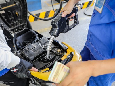Nhân viên cây xăng ở góc đường Lê Thánh Tôn (TP HCM) bơm xăng cho khách hàng. Ảnh: Nguyễn Thành.