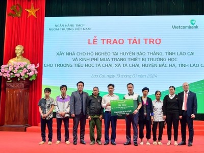 Ông Lê Hoàng Tùng - Phó tổng giám đốc Vietcombank (thứ 5 từ phải sang) cùng ông Đặng Việt Hùng – Bí thư Chi bộ, Giám đốc Vietcombank Lào Cai (ngoài cùng bên phải) trao biểu trưng số tiền 300 triệu đồng cho 6 hộ gia đình khó khăn tại huyện Bảo Thắng.
