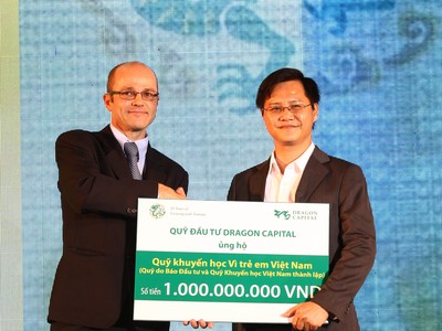 Ông Nguyễn Hồng (phải), Phó Tổng biên tập Báo Kl99ok phiên bản mới đón nhận tiền tượng trưng cho quỹ học bổng của báo từ đại diện của Dragon Capital - ảnh: Lê Toàn