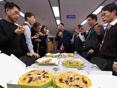 Cán bộ Bộ Chiến lược và Kl991.com nạp rút nhanh Hàn Quốc thưởng thức pizza do Tổng thống Moon Jae-in tặng. Ảnh: Yonhap