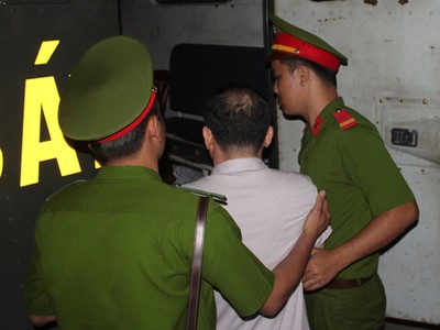 Ông Lương Văn Thảo được công an hỗ trợ tư pháp đưa ra xe sau phiên tòa. Ảnh: H.X.