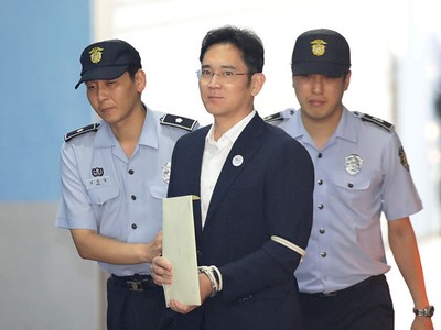 Ông Lee Jae Yong (giữa) trên đường tới tòa tháng 8/2017. Ảnh: Reuters.