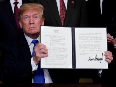 Tổng thống Donald Trump ký bản ghi nhớ áp thuế với Trung Quốc hôm 22/3. Ảnh: Reuters.