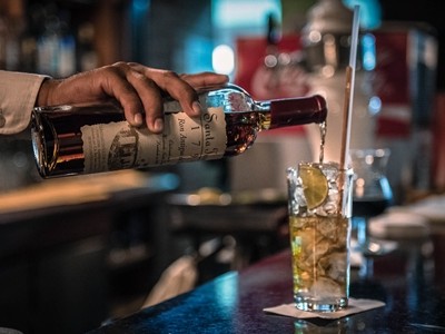 Một nhân viên pha chế đang làm cocktail với rượu rum tại Venezuela. Ảnh: Bloomberg.