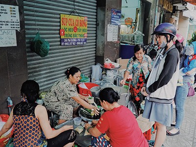 Khách đứng trước nồi súp chờ mua mang về. Ảnh: Di Vỹ.