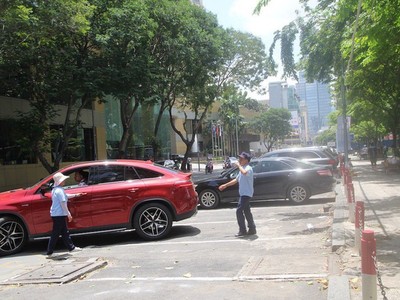 Thu phí ô tô đỗ dưới lòng đường tại TPHCM đang gặp nhiều khó khăn, thu không đủ bù chi. Trong ảnh: thu phí đỗ ô tô trên đường Lê Lai (quận 1).