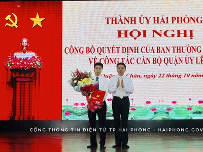Đồng chí Phạm Văn Hà, Ủy viên Ban Thường vụ Thành ủy, Trưởng Ban Tổ chức Thành ủy trao Quyết định và tặng hoa chúc mừng đồng chí Phạm Văn Tân.