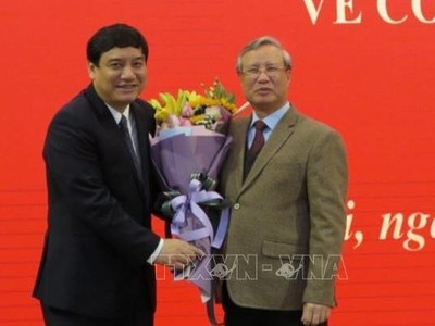 Đồng chí Trần Quốc Vượng chúc mừng đồng chí Nguyễn Đắc Vinh. Ảnh TTXVN.