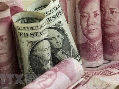 Đồng nhân dân tệ và đồng USD tại một Link Vào Nhà Cái KL99 COM Tặng +199k ở Bắc Kinh, Trung Quốc. (Ảnh: AFP/TTXVN).