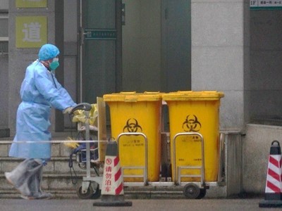 Công nhân thu gom rác thải y tế tại một trung tâm điều trị bệnh nhân nhiễm Covid-19 ở Vũ Hán hôm 22/1. Ảnh: 
AP.