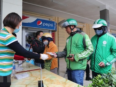 Phát miễn phí khẩu trang y tế cho lái xe Grab. (Ảnh: Thành Đạt/TTXVN).