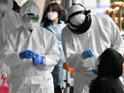 Nhân viên y tế Hàn Quốc lấy mẫu xét nghiệm nCoV cho một phụ nữ ở Seoul ngày 10/3. Ảnh: AFP.